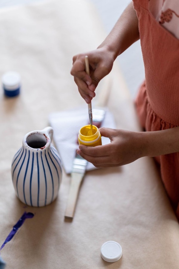 Artisan hand-painting ceramic tile mural in Mansoura studio